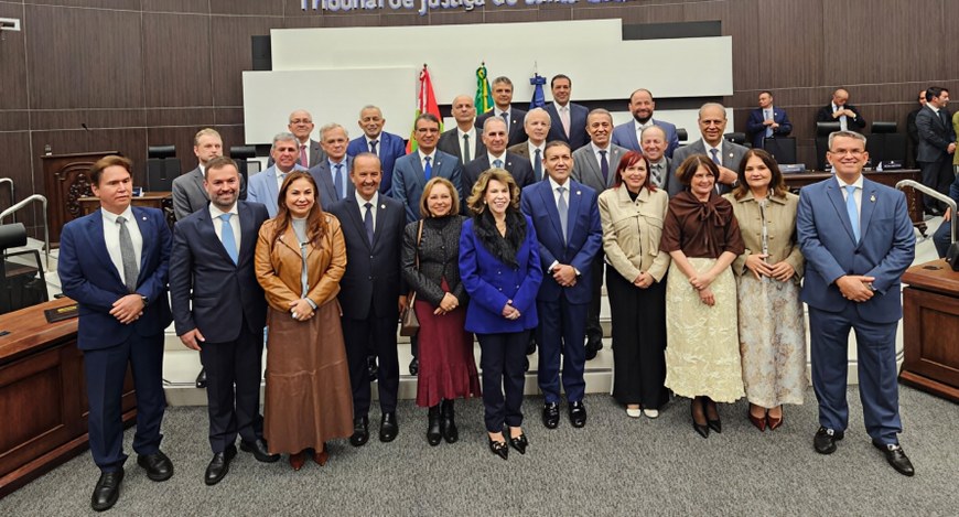 mostra um grupo de aproximadamente vinte e quatro pessoas reunidas para uma foto oficial em um a...
