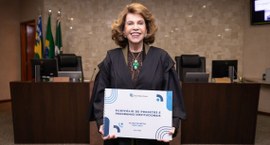 Presidente do TRE-GO segurando o portfólio de projetos.
