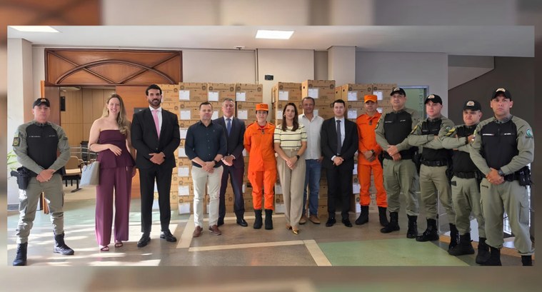 Uma fotografia de grupo de cerca de vinte pessoas posando para a câmera em um ambiente interno. ...