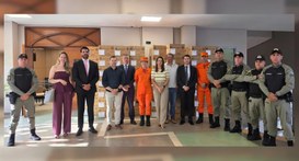 Uma fotografia de grupo de cerca de vinte pessoas posando para a câmera em um ambiente interno. ...
