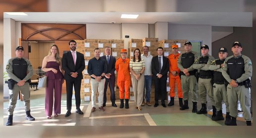 Uma fotografia de grupo de cerca de vinte pessoas posando para a câmera em um ambiente interno. ...