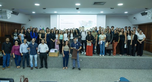 Uma fotografia de grupo de cerca de cinquenta pessoas, a maioria jovens adultos, posando para um...