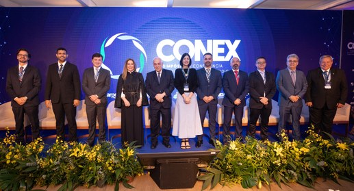 A imagem mostra um grupo de onze pessoas, composto por dez homens e uma mulher, posando alinhado...
