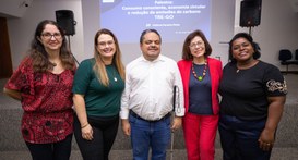 A imagem destaque.jpg mostra cinco pessoas posando sorridentes lado a lado em um auditório, posi...