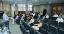 A imagem mostra uma sala de reuniões ou pequeno auditório durante uma apresentação ou treinament...